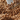 A metal scoop pours a pile of hazelnuts, with many hazelnuts scattered across the surface, creating a rich, textured background. - AI generated text